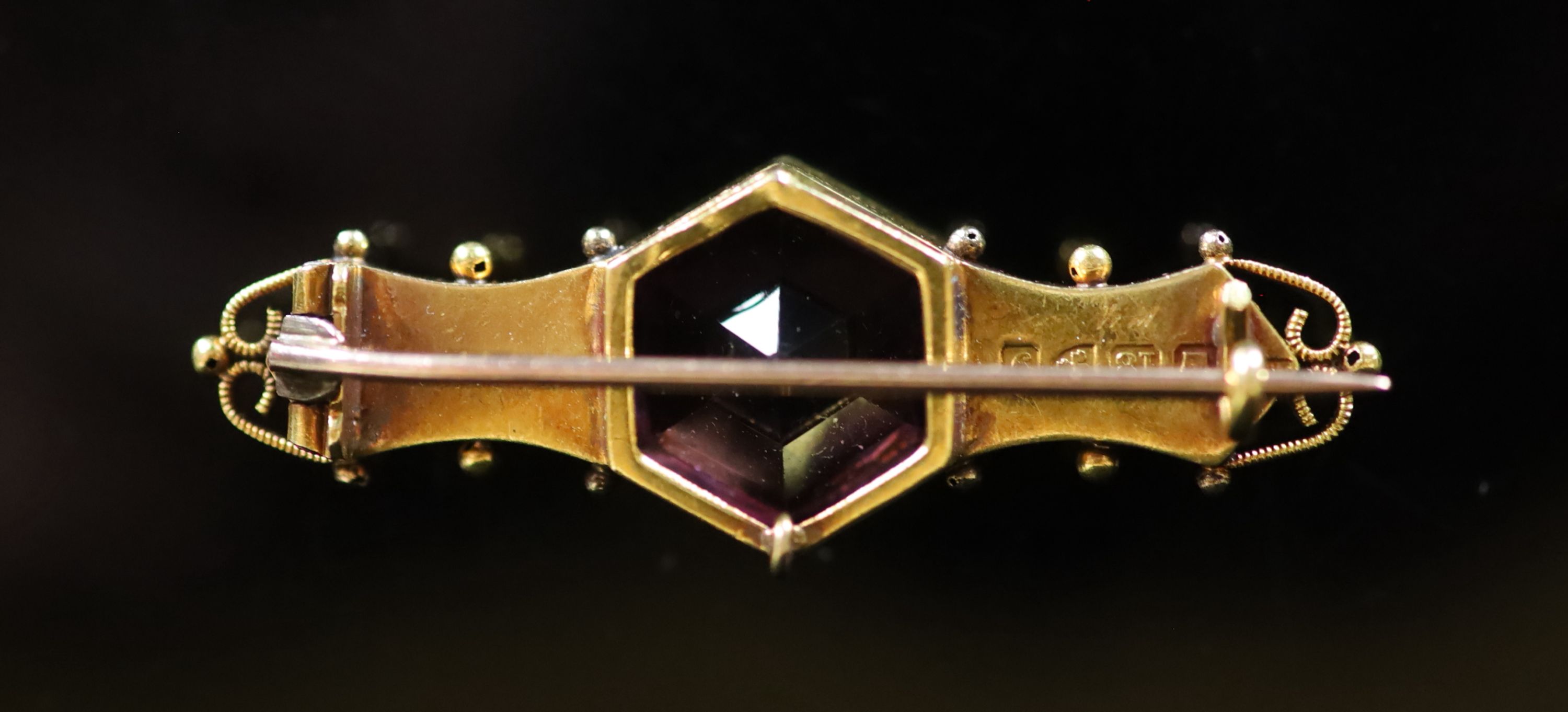 An Edwardian 18ct gold, hexagonal cut amethyst and diamond set three stone bar brooch